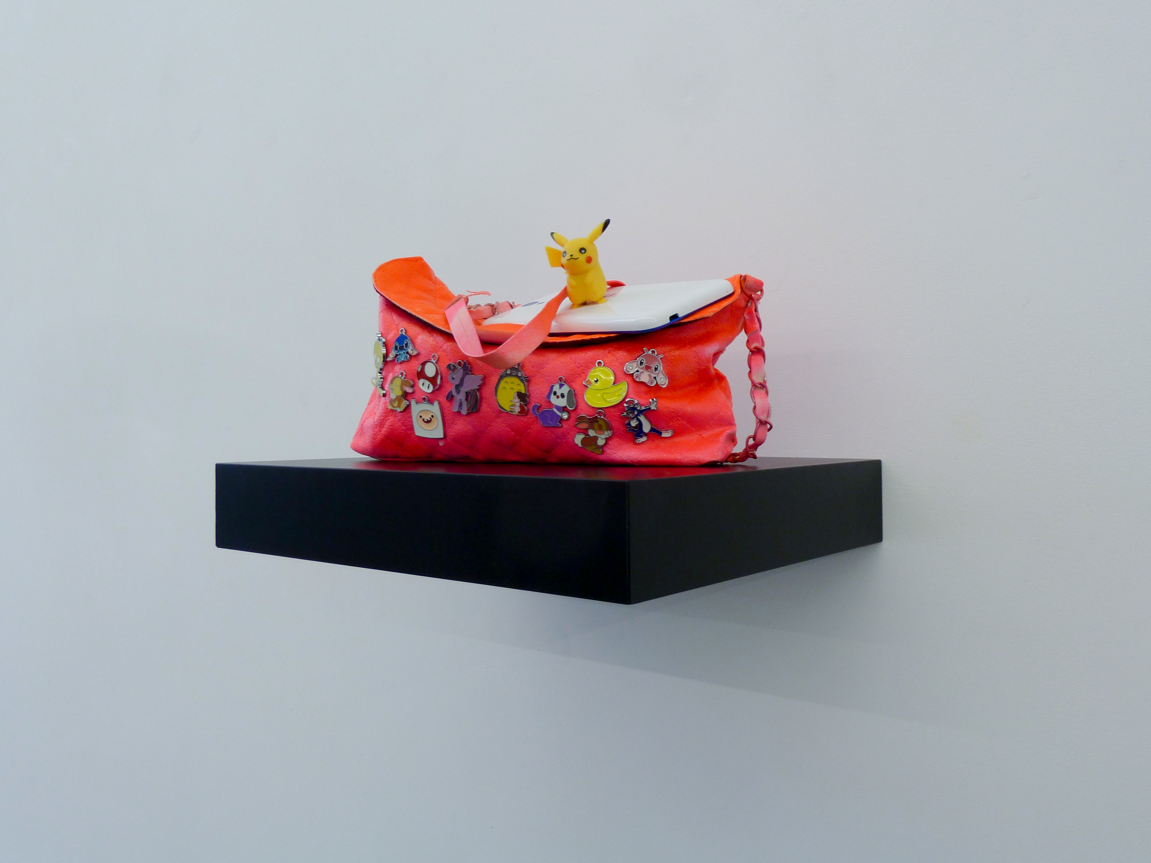 Michael Pybus, Shoulder Clutch (Neon Pink), 2017, handbag, spray paint, enamel badges, plastic figure and dummy cell phone, approx 32 x 15 x 16 cm